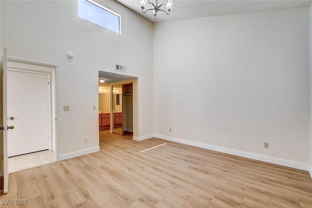 8233 Willeta Ave, Las Vegas, NV 89145 - spare room featuring light wood finished floors, a chandelier, and baseboards