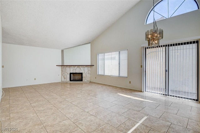 8233 Willeta Ave, Las Vegas, NV 89145 - unfurnished living room with a chandelier, high vaulted ceiling, a stone fireplace, healthy amount of natural light, and tile patterned flooring