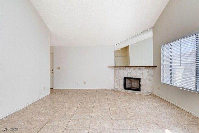 8233 Willeta Ave, Las Vegas, NV 89145 - unfurnished living room featuring a fireplace with raised hearth and light tile patterned floors
