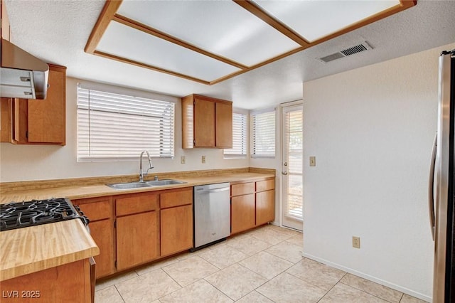8233 Willeta Ave, Las Vegas, NV 89145 - kitchen featuring stainless steel appliances, a sink, range hood, butcher block countertops, and light tile patterned flooring