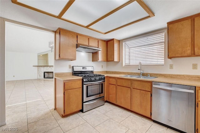 8233 Willeta Ave, Las Vegas, NV 89145 - kitchen with stainless steel appliances, a sink, under cabinet range hood, light countertops, and light tile patterned flooring