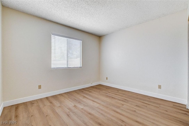 8233 Willeta Ave, Las Vegas, NV 89145 - unfurnished room featuring light wood finished floors, a textured ceiling, and baseboards