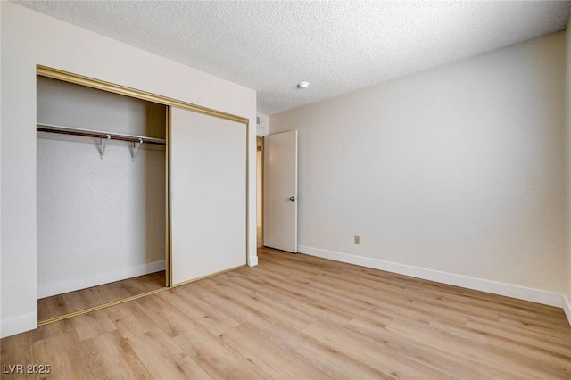 8233 Willeta Ave, Las Vegas, NV 89145 - unfurnished bedroom featuring wood finished floors, a closet, a textured ceiling, and baseboards