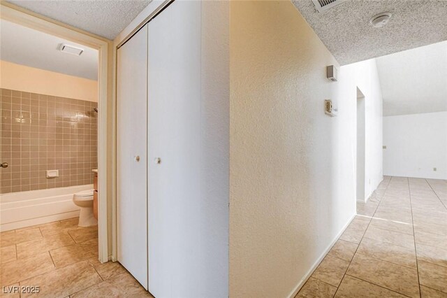 8233 Willeta Ave, Las Vegas, NV 89145 - corridor with tile patterned flooring, a textured ceiling, and a textured wall