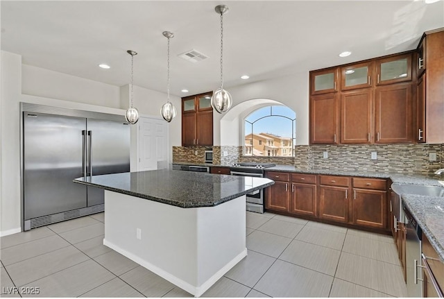 6507 Creekside Cellars Ct, Las Vegas, NV 89139 - kitchen featuring appliances with stainless steel finishes, tasteful backsplash, light tile patterned flooring, dark stone counters, and recessed lighting