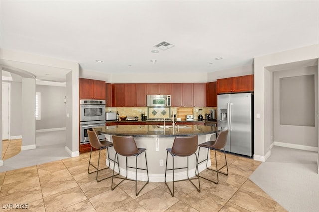 900 Cantura Mills Rd, Henderson, NV 89052 - kitchen featuring stainless steel appliances, a kitchen breakfast bar, backsplash, a center island with sink, and baseboards