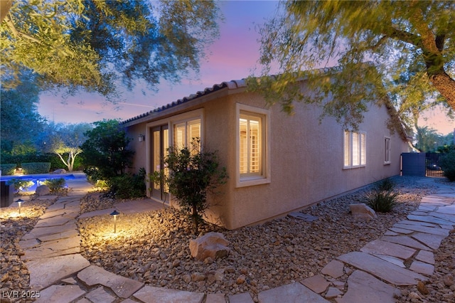 900 Cantura Mills Rd, Henderson, NV 89052 - property exterior at dusk with stucco siding, an outdoor pool, and a tile roof