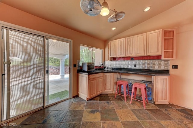 1523 Silver Point Ave, Las Vegas, NV 89123 - kitchen with tasteful backsplash, dark countertops, stone tile flooring, vaulted ceiling, and light brown cabinetry
