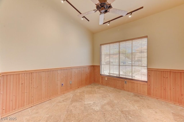 1523 Silver Point Ave, Las Vegas, NV 89123 - unfurnished room with rail lighting, wainscoting, wood walls, ceiling fan, and stone finish flooring