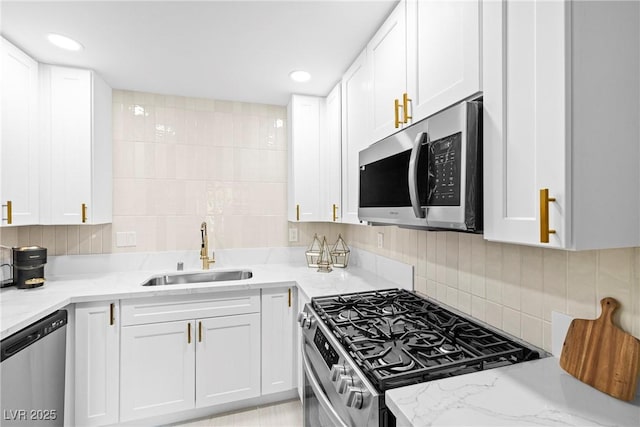 5191 Caliente St Unit 84, Las Vegas, NV 89119 - kitchen with stainless steel appliances, a sink, white cabinets, backsplash, and recessed lighting