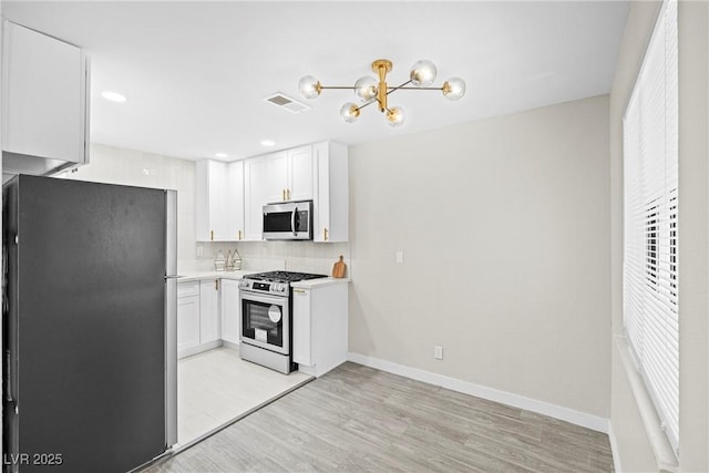 5191 Caliente St Unit 84, Las Vegas, NV 89119 - kitchen featuring stainless steel appliances, light wood-style flooring, white cabinets, backsplash, and light countertops