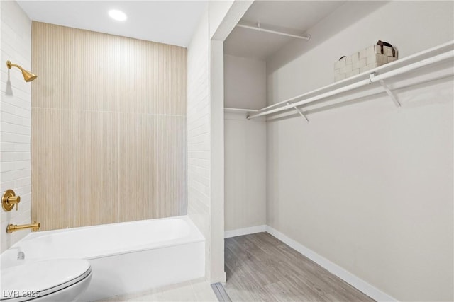 5191 Caliente St Unit 84, Las Vegas, NV 89119 - bathroom featuring bathtub / shower combination, toilet, wood finished floors, a walk in closet, and baseboards
