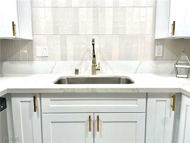 5191 Caliente St Unit 84, Las Vegas, NV 89119 - kitchen with a sink, decorative backsplash, white cabinets, and light stone countertops