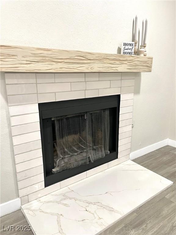 5191 Caliente St Unit 84, Las Vegas, NV 89119 - detailed view of a tile fireplace, baseboards, and wood finished floors
