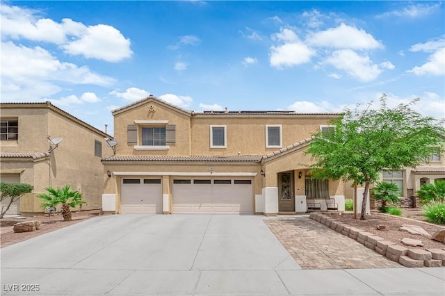 1808 Peyton Stewart Ct, North Las Vegas, NV 89086 - view of front of home with an attached garage, concrete driveway, a tiled roof, stucco siding, and roof mounted solar panels