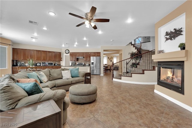 1808 Peyton Stewart Ct, North Las Vegas, NV 89086 - living room with stairs, a ceiling fan, a multi sided fireplace, baseboards, and recessed lighting