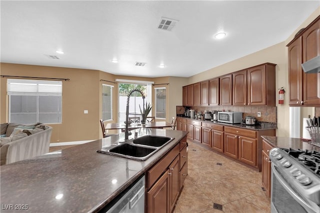 1808 Peyton Stewart Ct, North Las Vegas, NV 89086 - kitchen with appliances with stainless steel finishes, tasteful backsplash, a sink, recessed lighting, and dark stone countertops