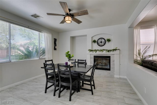 11004 Napa Ridge Dr, Las Vegas, NV 89144 - dining room with a ceiling fan, a fireplace, baseboards, and light marble finish flooring