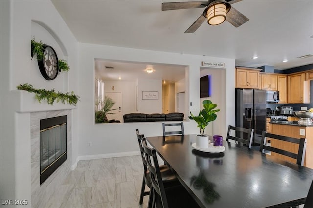11004 Napa Ridge Dr, Las Vegas, NV 89144 - dining area featuring a ceiling fan, light marble finish floors, a fireplace, baseboards, and recessed lighting