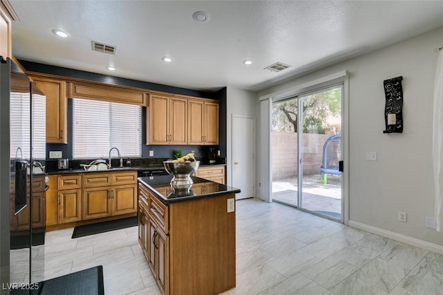 11004 Napa Ridge Dr, Las Vegas, NV 89144 - kitchen featuring a sink, a kitchen island, recessed lighting, brown cabinets, and baseboards