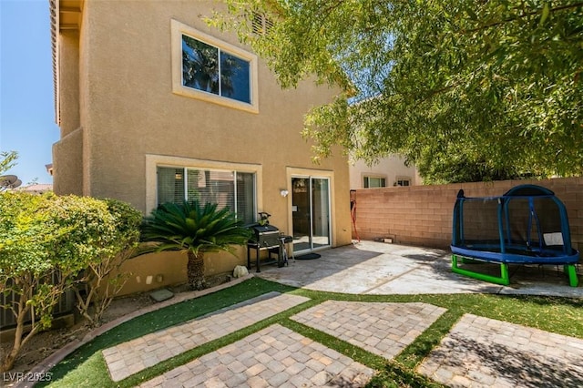 11004 Napa Ridge Dr, Las Vegas, NV 89144 - back of house featuring a patio area, a trampoline, and stucco siding