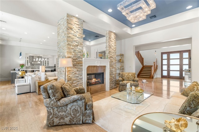 11 Misty Peaks Ct, Las Vegas, NV 89135 - living room featuring stairway, recessed lighting, a multi sided fireplace, a raised ceiling, and french doors