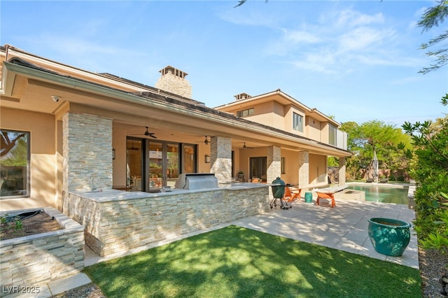 11 Misty Peaks Ct, Las Vegas, NV 89135 - back of house with exterior kitchen, stucco siding, a ceiling fan, and a patio