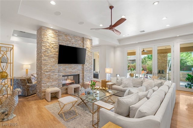 11 Misty Peaks Ct, Las Vegas, NV 89135 - living room with a raised ceiling, ceiling fan, recessed lighting, light wood-type flooring, and a stone fireplace