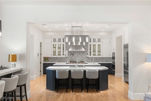 11 Misty Peaks Ct, Las Vegas, NV 89135 - kitchen featuring high end refrigerator, light wood-style flooring, a breakfast bar, and white cabinets