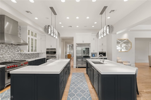 11 Misty Peaks Ct, Las Vegas, NV 89135 - kitchen with wall chimney range hood, high quality appliances, a large island with sink, a sink, and recessed lighting