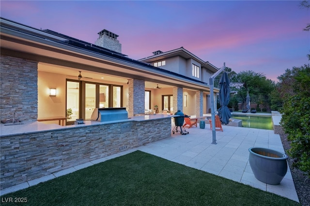 11 Misty Peaks Ct, Las Vegas, NV 89135 - back of property at dusk featuring a ceiling fan, area for grilling, a patio area, and stucco siding