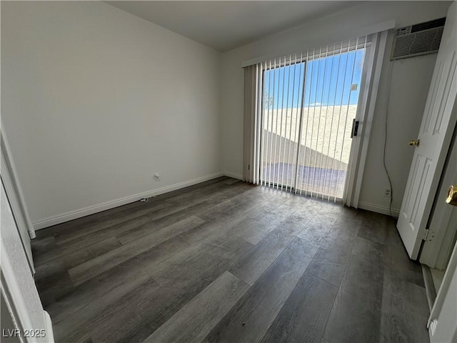 6905 Singing Dunes Ln, Las Vegas, NV 89145 - empty room featuring dark wood finished floors, baseboards, and an AC wall unit