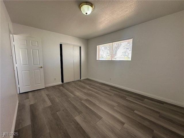 6905 Singing Dunes Ln, Las Vegas, NV 89145 - unfurnished bedroom with dark wood finished floors, a closet, baseboards, and a textured ceiling