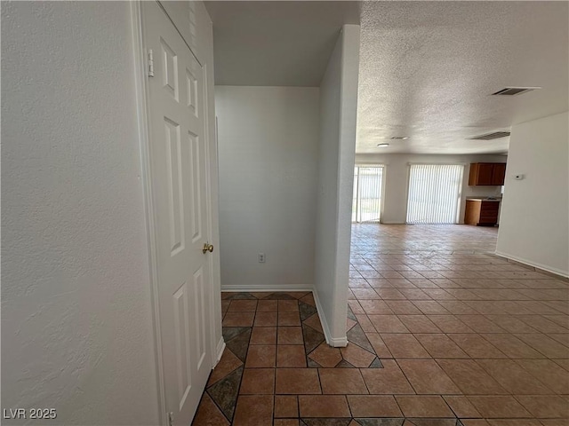 6905 Singing Dunes Ln, Las Vegas, NV 89145 - corridor featuring tile patterned flooring, baseboards, and a textured ceiling