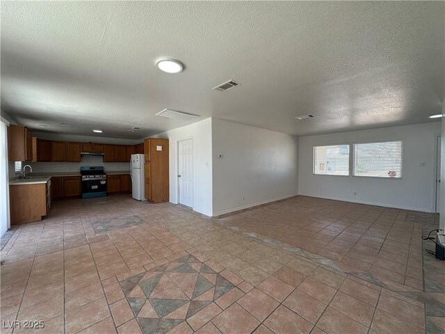 6905 Singing Dunes Ln, Las Vegas, NV 89145 - unfurnished living room featuring a textured ceiling, a sink, and baseboards