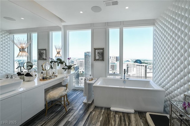 3750 Las Vegas Blvd Unit 4303, Las Vegas, NV 89158 - full bathroom featuring a soaking tub, double vanity, wood finished floors, and plenty of natural light