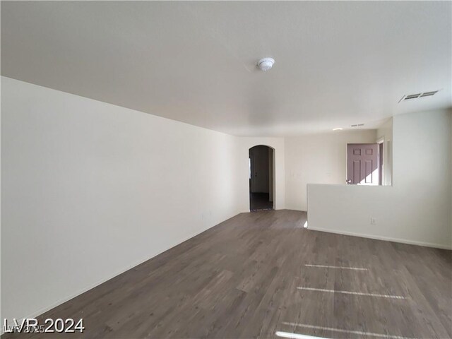 2711 Morning Break Ct, Las Vegas, NV 89142 - unfurnished room featuring arched walkways, wood finished floors, and a smoke detector