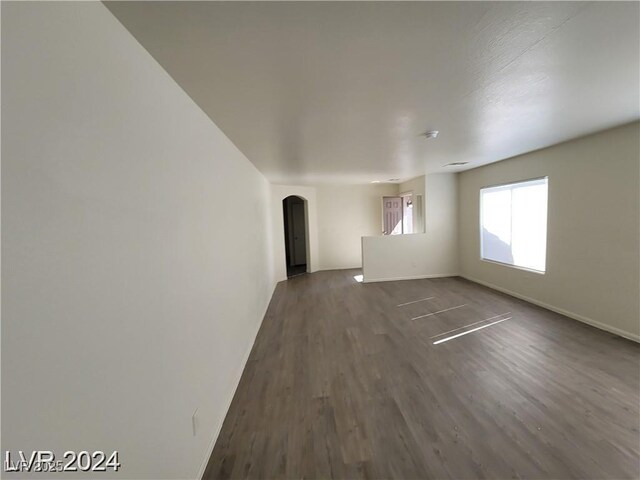 2711 Morning Break Ct, Las Vegas, NV 89142 - empty room with arched walkways, dark wood-style flooring, and baseboards