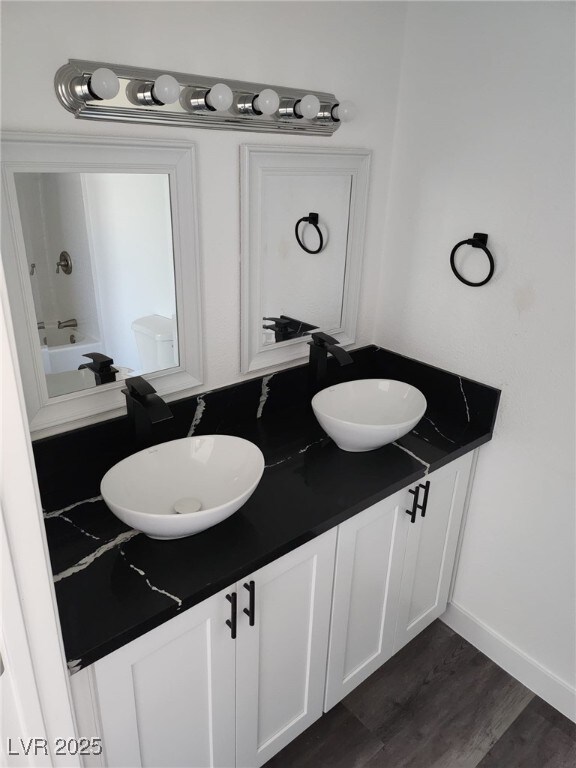 4231 E Kellogg Rd, Pahrump, NV 89061 - bathroom with double vanity, wood finished floors, and a bath