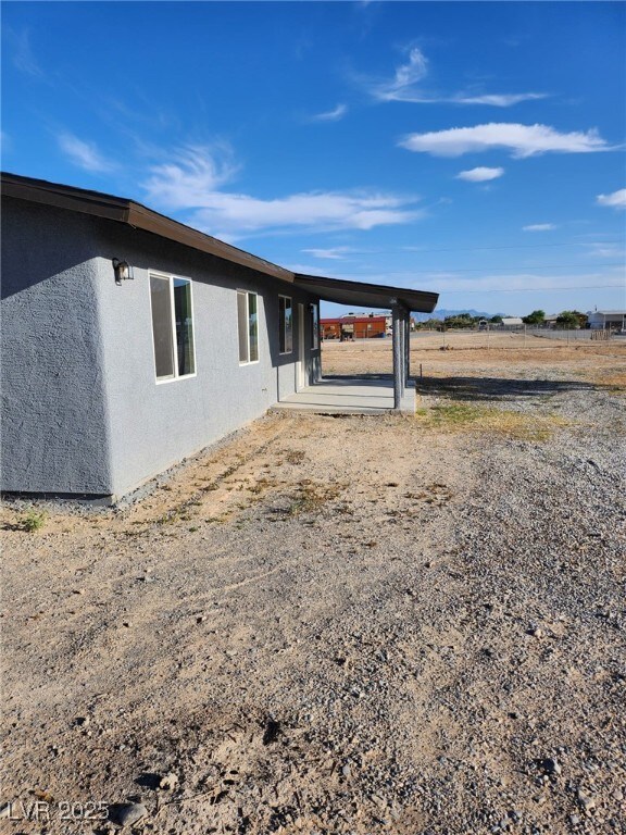 4231 E Kellogg Rd, Pahrump, NV 89061 - view of home's exterior with stucco siding and a carport