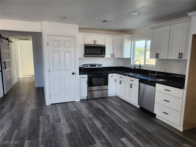 4231 E Kellogg Rd, Pahrump, NV 89061 - kitchen with stainless steel appliances, dark countertops, a sink, and white cabinets