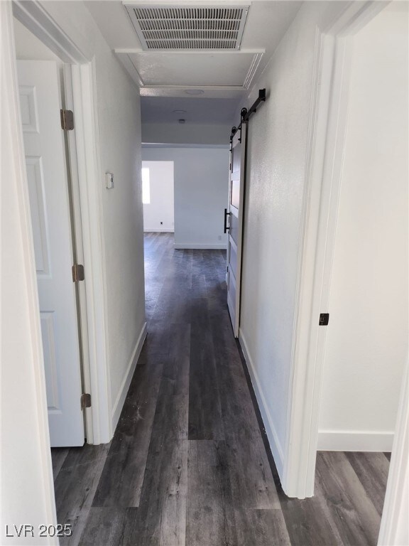 4231 E Kellogg Rd, Pahrump, NV 89061 - hallway with dark wood-style floors, baseboards, and a barn door