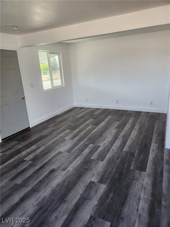 4231 E Kellogg Rd, Pahrump, NV 89061 - spare room featuring baseboards and dark wood-style flooring