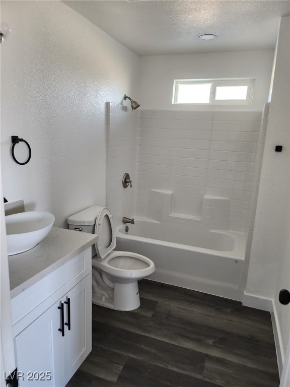 4231 E Kellogg Rd, Pahrump, NV 89061 - full bathroom with vanity, toilet, wood finished floors, bathing tub / shower combination, and a textured ceiling