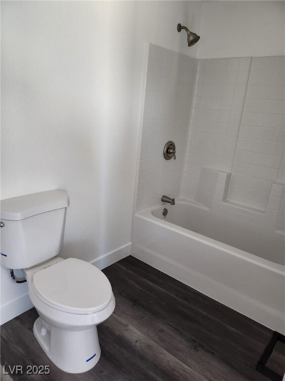 4231 E Kellogg Rd, Pahrump, NV 89061 - full bath with baseboards, toilet, shower / bathtub combination, and wood finished floors