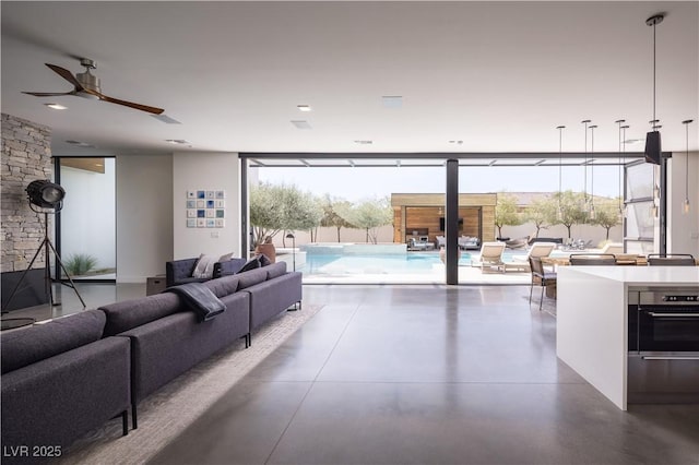 7030 Schirlls St, Las Vegas, NV 89118 - living area featuring ceiling fan, finished concrete floors, and a wall of windows