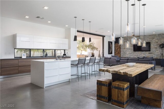 7030 Schirlls St, Las Vegas, NV 89118 - kitchen featuring modern cabinets, concrete flooring, hanging light fixtures, white cabinets, and recessed lighting