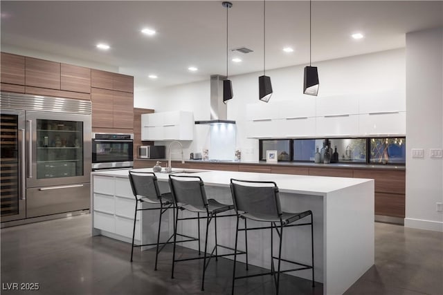 7030 Schirlls St, Las Vegas, NV 89118 - kitchen featuring modern cabinets, appliances with stainless steel finishes, island range hood, a kitchen breakfast bar, and recessed lighting