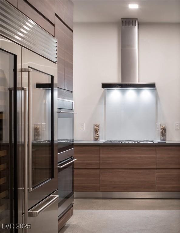 7030 Schirlls St, Las Vegas, NV 89118 - kitchen featuring wall chimney exhaust hood, built in fridge, and modern cabinets