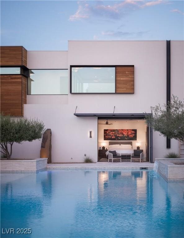 7030 Schirlls St, Las Vegas, NV 89118 - rear view of property with stucco siding, outdoor lounge area, and a pool with connected hot tub